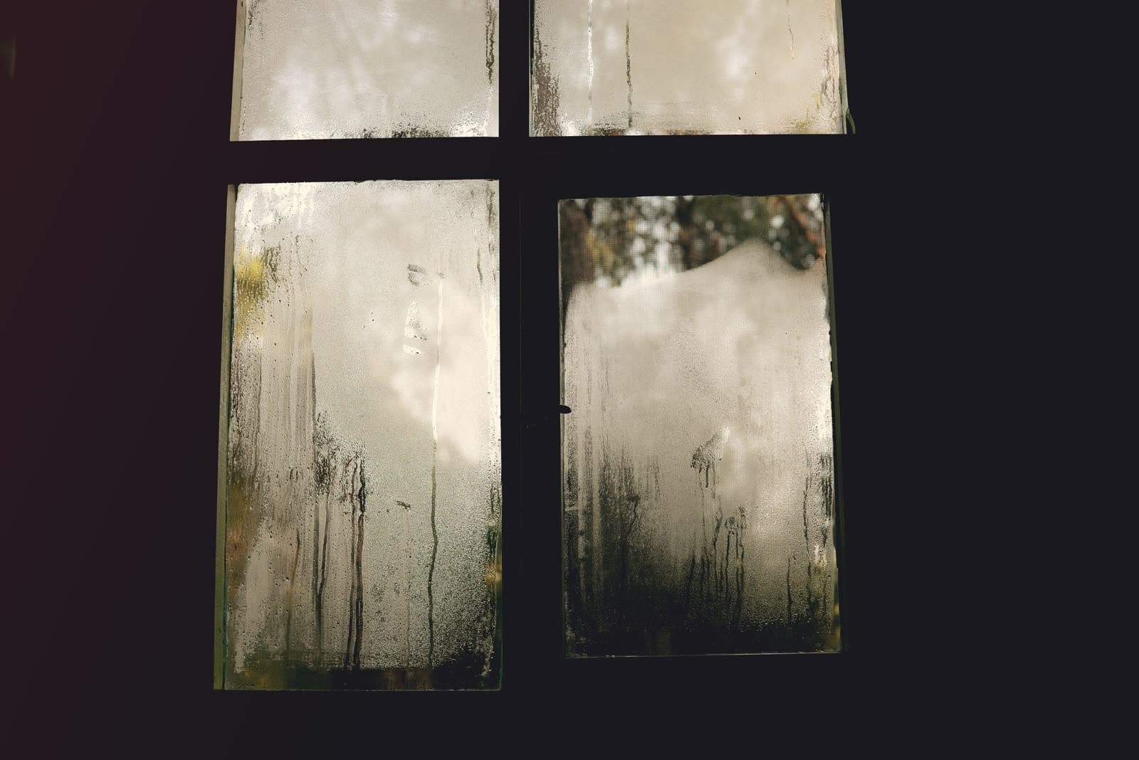 Cristales de una ventana empañados por dentro, con la condensación resbalando hasta el marco